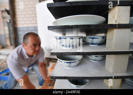 (191016) - NANCHANG, Oktober 16, 2019 (Xinhua) - ein Mitglied der Mannschaft "Kuaixueshiqing" nimmt neue Porzellanmanufaktur in Jingdezhen, im Osten der chinesischen Provinz Jiangxi, Okt. 15, 2019. Ei Schale Porzellan, einem renommierten Art der traditionellen Porzellan Arbeit in Jingdezhen von Jiangxi produziert, ist berühmt für seine dünnen und transparenten Körper, so besonders macht. Wang Minhui, 40, ist Leiter der Eierschale Porzellan, Team namens 'Kuaixueshiqing'. Wang und seine beiden Partner Du Xingyu und Liu Zhen, die Interesse an Porzellan, gründete das Team im Jahr 2010. Das Team, jetzt mit über 20 Mitgliedern, hat in Bestand Stockfoto