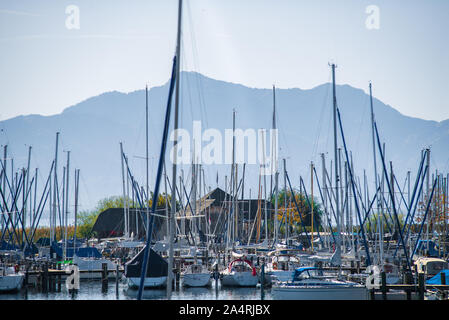 Blick auf festgebundene Segelboote in einem See mit den Alpen im Hintergrund Stockfoto