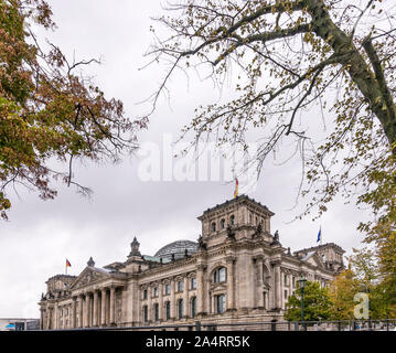 Der Palast der Reichstag (Parlament) von Berlin, Deutschland, die von den Zweigen der Bäume in Herbstfarben eingerahmt Stockfoto