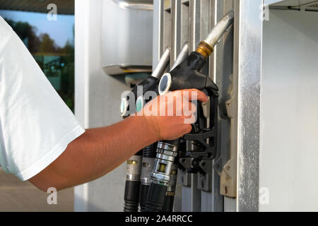 Tankstelle Pumpe. Man füllt sich sein Auto mit Benzin an der Tankstelle. Zu Auto mit Kraftstoff füllen. Benzin und Öl Produkte. Stockfoto