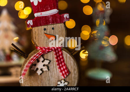 Weihnachtsschmuck gegen verschwommenen Hintergrund. Kleine Holz- Schneemann. Stockfoto