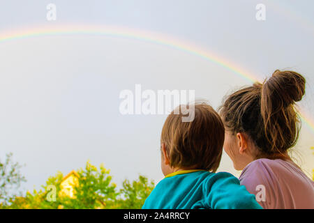 Mutter mit einem Kind sucht im Rainbow. Mutter und Sohn auf dem Hintergrund der Mutterschaft. Im Rainbow. Stockfoto