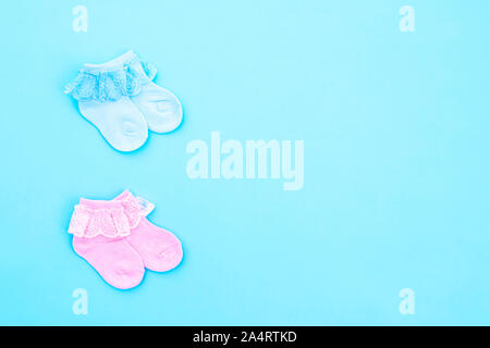 Zwei paar Blau und Pink cute Baby Socken auf blauem Hintergrund. Baby Accessoires. Flach. Stockfoto