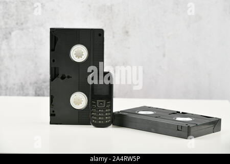 Retro Objekte auf einem weißen Hintergrund. push-button Telefon und Video Kassette. Analoge Medien Technologie der Vergangenheit an. Platz kopieren Stockfoto