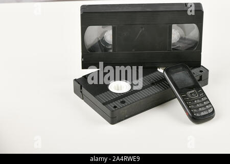 Retro Objekte auf einem weißen Hintergrund. push-button Telefon und Video Kassette. Analoge Medien Technologie der Vergangenheit an. Platz kopieren Stockfoto