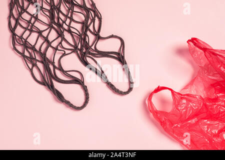Plastikbeutel mit mesh textile auf rosa Hintergrund. Flach, Ansicht von oben. Flach, Ansicht von oben. Stockfoto