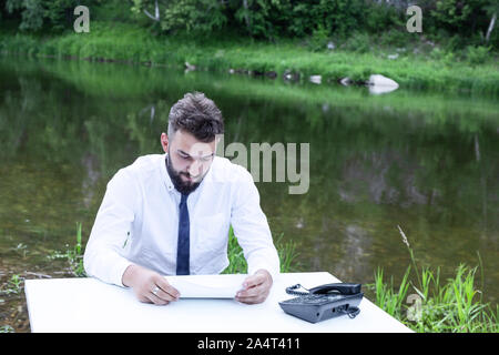 Unternehmer auf der Suche nach Betrug und Vertrag Fehler. Eine junge Bartgeier business Mann Lesen von Dokumenten. Stockfoto