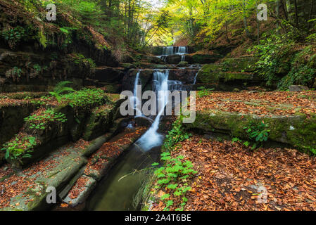 Wasserfall unter der steinernen Brücke in Rhodope Berg in der Nähe von Sitovo Dorf, Region Plovdiv, Bulgarien, Europa. Herbst Fotografie mit warmen Farben und falli Stockfoto