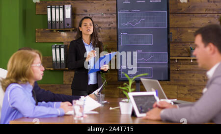 Erfolgreicher Geschäftsmann lesen Charts auf seinem Tablet. Geschäftsmann mit seinem Team in den Konferenzraum. Stockfoto