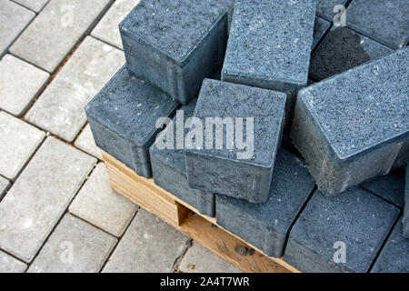 Dunkel grau Pflastersteine für Straßenarbeiten auf Holzpaletten, unter hellen Pflastersteine Stockfoto