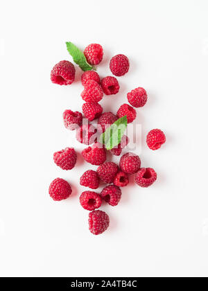 Haufen frischen reifen roten Himbeeren mit grünen Blättern auf weißem Hintergrund. Top View oder flach. Vertikale Stockfoto