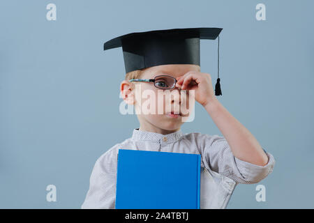 Redhead erster Sortierer Junge in Student hat mit Büchern in Händen setzt seine Brille Stockfoto