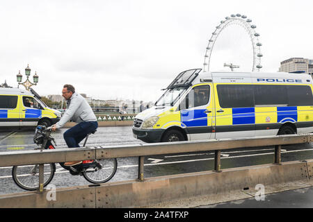 London, UK, 16. Oktober 2019. Polizei Transporter auf die Westminster Bridge stationiert nach § 14 öffentliche Ordnung ausgestellt wurde das Verbot Protest von Klima Aktivisten vor dem Aussterben Rebellion, die thretened hat das Verbot in die Hohen Gerichte in Frage zu stellen. Credit: Amer ghazzal/Alamy leben Nachrichten Stockfoto