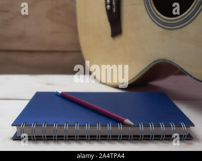 Bleistift und Buch auf Holztisch, Stockfoto