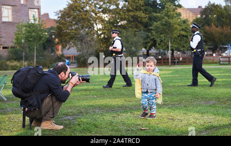 London, Großbritannien. 15. Oktober 2019. 2 Jährige Demonstrant Tendai, spielt zwar fotografiert werden, als das Aussterben Rebellion Protest im Vauxhall Gärten von der Polizei geschlossen ist. Quelle: Thomas Bowles/Alamy leben Nachrichten Stockfoto