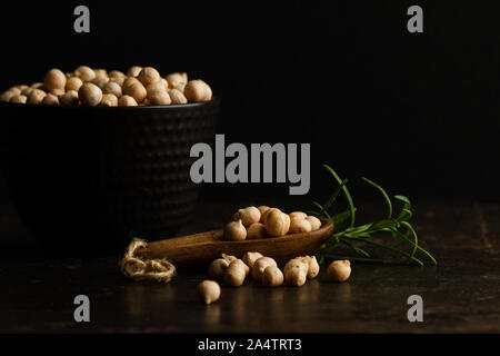 Kichererbsen in einem schwarzen Keramik Schüssel auf einem dunklen Hintergrund Stockfoto