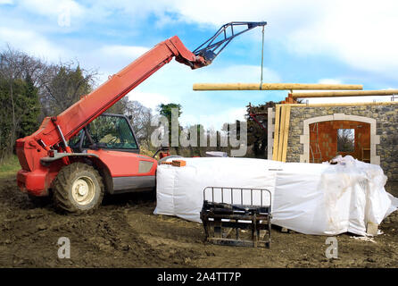 Bau einer Holz-stein-brick House mit einem teleskopierbaren Kran. Stockfoto