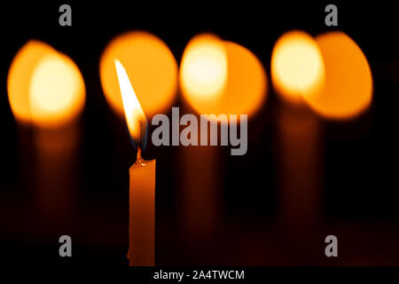 Kerze - Nahaufnahme von einem brennenden & Schmelzen Wachs Kerzen, schöne Bokeh lichter Hintergrund in Schwarz isoliert. Konzept für Diwali, Weihnachten Stockfoto