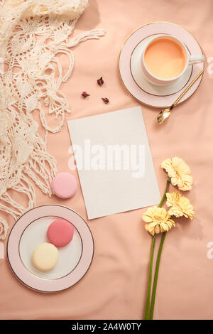 Umschlag, Blumen, und macarons mit Tasse Tee auf hellen Hintergrund Stockfoto