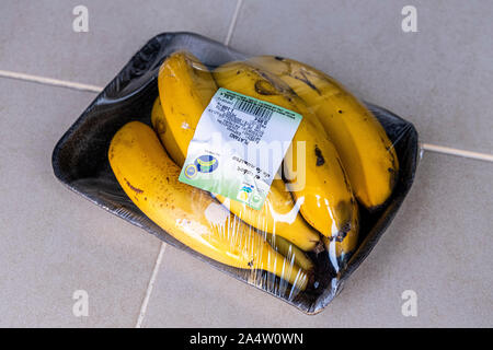 Kanarische Bananen in Kunststoff und Kunststoff Frischhaltefolie einwickeln verpackt Stockfoto