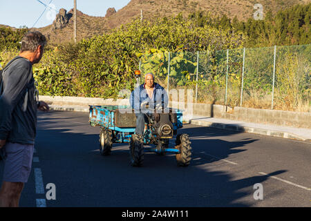 Bauer fahren kleine angetriebene Fahrzeug und Anhänger die Straße entlang in Valle Arriba, Santiago del Teide, Teneriffa, Kanarische Inseln, Spanien Stockfoto