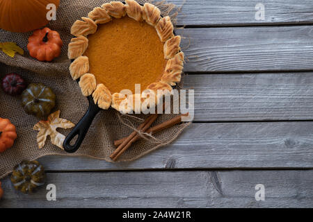 Hausgemachte Pumpkin Pie gebacken in gusseisernen Pfanne, auf hölzernen Hintergrund Stockfoto