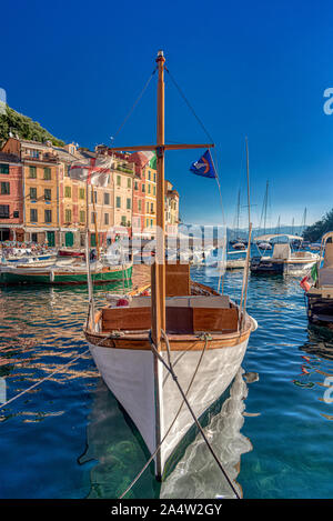 Leeren weißen Holzboot mit kurzen kreuzförmige Mast, in Portofino Bay günstig, Italien, gesehen vom Bug mit Reflexion in ruhigem Wasser Stockfoto