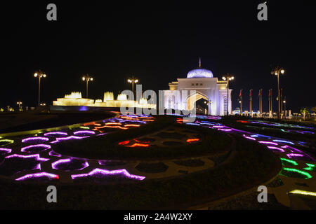 Nacht Presidential Palace Gate und bunte Brunnen in Abu Dhabi, Vereinigte Arabische Emirate. Stockfoto