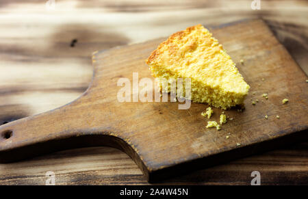 Einzelnen Stück cornbread auf einem kleinen hölzernen Schneidebrett. Stockfoto