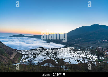 Kleines Dorf und Terraced Rice Fields von YuanYang, China mit Blick aufs Meer von Nebel und Wolken Stockfoto