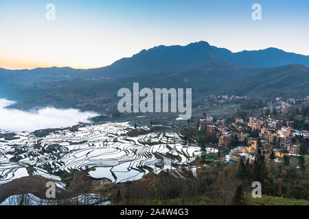 Kleines Dorf und Terraced Rice Fields von YuanYang, China mit Blick aufs Meer von Nebel und Wolken Stockfoto