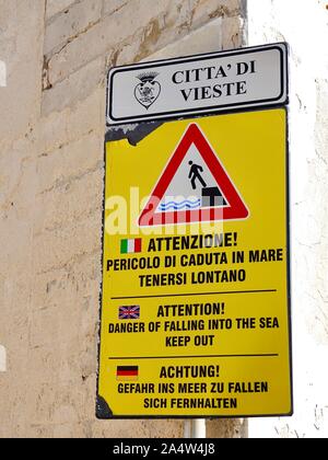 Die Stadt Vieste warnt davor, ins Meer zu fallen, auf Italienisch, Englisch und Deutsch, auf der Gargano-Halbinsel, Italien, Stockfoto