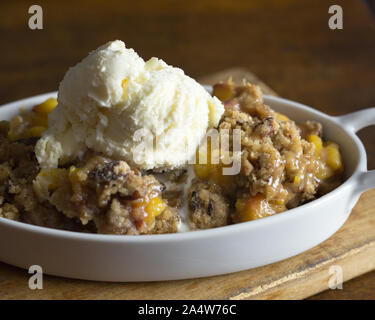 Nahaufnahme von Pfirsich und Pecan Schuster mit einem Schmelzpunkt Kugel Vanilleeis. Stockfoto