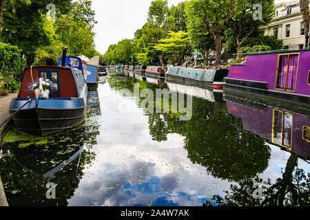 Blick auf Bunte schmale Boote in Klein Venedig Unter dem Warwick Avenue Road Bridge über den Grand Union Canal mit Baum Reflexionen Stockfoto