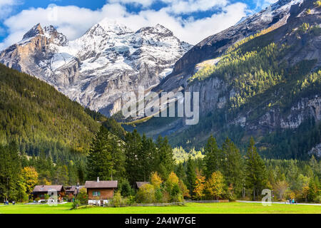 Bunte Holzhäuser in Kandersteg Dorf, Kanton Bern, Schweiz, Europa und Schnee Berge Panorama Stockfoto