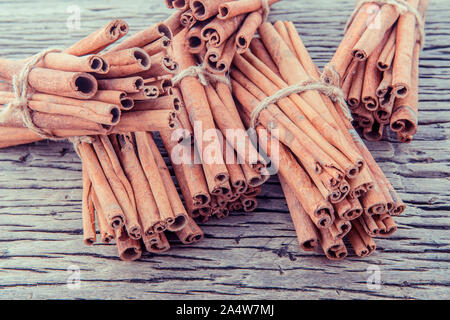 Gebunden Cinnamon Stick mit selektiven Fokus auf alten hölzernen Hintergrund. Stockfoto