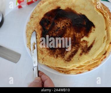 Verbreitung Schokoladencreme über dünne Pfannkuchen/köstliche Crêpes whit Schokoladencreme Stockfoto