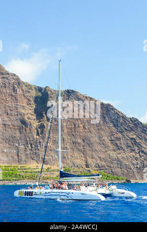 Madeira, Portugal - September 10, 2019: Bootstour in den Gewässern des Atlantischen Ozeans. Steile Felsen auf eine portugiesische Insel im Hintergrund. Wale, Delfine beobachten. Kreuzfahrt. Stockfoto