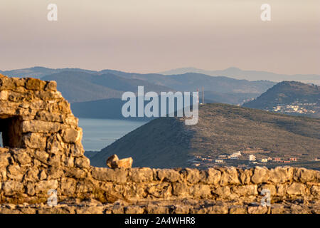 Goldene stunde Landschaft von Lekuresi Schloss, Saranda, Albanien mit unscharfen mittelalterlichen Steinmauer im Vordergrund, Clear Spring sky Stockfoto