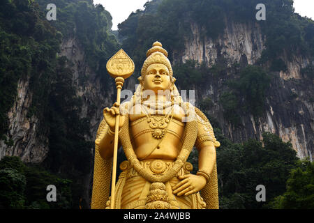 Gombak, Selangor, Malaysia 08.14.2019: Oberkörper Teil des riesigen und tollen golden Murugan Statue mit dem berühmten Hügel aus Kalkstein von Batu Höhlen in Stockfoto