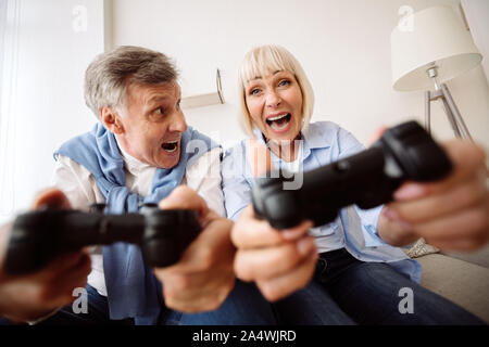 Ältere Paare spielen Videospiele zu Hause überglücklich Stockfoto