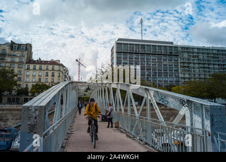 PARIS, Frankreich, 3. OKTOBER, 2019: Radfahrer Kreuzung Fußgängerbrücke über Bassin de l'Arsenal in der Nähe von Place de la Bastille in Paris Stockfoto