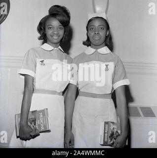 1967, historisch, zwei neu qualifizierte ausländische Krankenschwestern stehen zusammen für ein Foto, Stoke mandeville Hospital, Aylesbury, Bucks, England, UK. In den 1950er und 60er Jahren wurden Tausende von Krankenschwestern aus Übersee, viele aus Jamaika, der Karibik und anderen Gebieten des britischen commonwealth, für die Arbeit im National Health Service (NHS) rekrutiert. Stockfoto