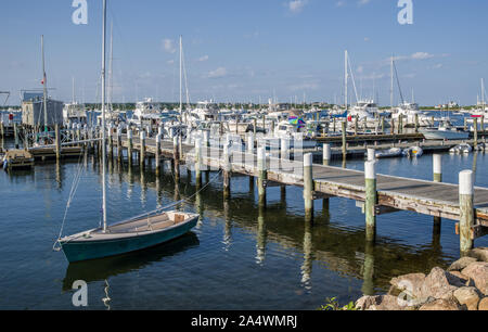 Kleines Segelboot auf ein neues England Wharf: ein kleines Boot sitzt auf einem hölzernen Pier auf einen ruhigen Sommer Abend in Rhode Island. Stockfoto