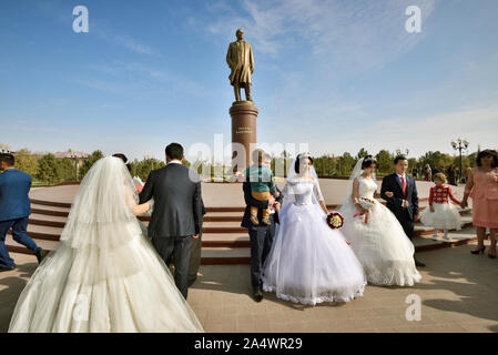 Mehrere Hochzeiten vor der Statue des verstorbenen Führer Islam Karimow, ein Muss für die fotosessions. Samarkand, Usbekistan Stockfoto