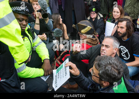 London, Großbritannien. 16. Oktober, 2019. Die Metropolitan Police Officers vorbereiten zu verhaften, Jonathan Bartley (c), Co - Führer der Grünen Partei, George Monbiot Guardian (r) und eine Gruppe von Aktivisten vor dem Aussterben Rebellion mit Abschnitt 14 der öffentlichen Ordnung von 1986, nachdem Sie in der Straße in Whitehall setzte nach einer Volksversammlung in Trafalgar Square als Teil der Protest gegen den Einsatz von der Metropolitan Police von Abschnitt 14 so gänzlich verhindern Aussterben Rebellion Herbst Aufstand Proteste in der Hauptstadt. Credit: Mark Kerrison/Alamy leben Nachrichten Stockfoto