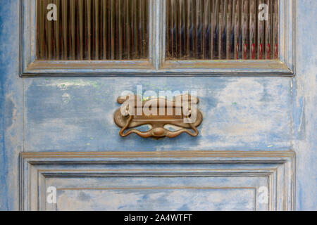 Reich verzierte Letterbox n einer Verwitterten blau Holz Haustür im Detail gesehen Stockfoto