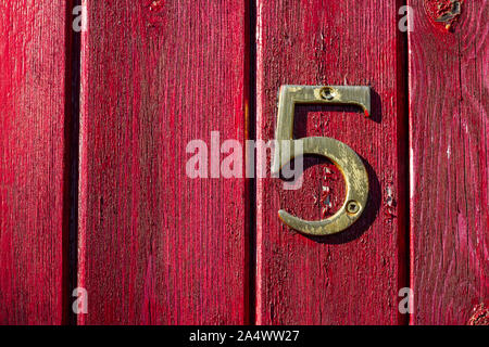 Haus Nummer 5 auf eine alte Holztür mit Risse im Lack Stockfoto