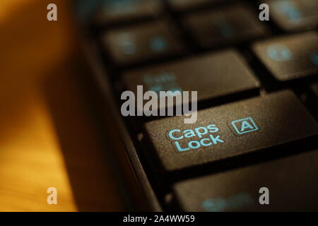 Tastatur in Schwarz auf der sonnigen Tabelle Nahaufnahme. Fokussierung auf Key Caps Lock Stockfoto