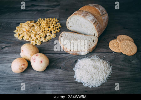 Gemeinsame schlechte Kohlenhydrate zu vermeiden wie weißes Brot, Teigwaren, Reis, Kartoffeln und buscuits Festlegung auf einen hölzernen Tisch von oben gesehen Stockfoto